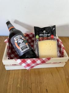 a bottle of wine and cheese in a basket at Casa Malvina in A Coruña