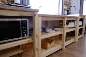 a microwave oven sitting on top of a wooden cabinet at Bakonyi Porta Olaszfalu in Olaszfalu +41 photos