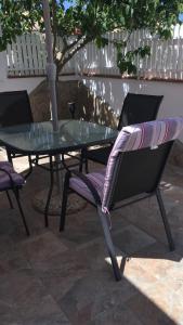 une table en verre et deux chaises sur la terrasse dans l'établissement Casa Iris, à Conil de la Frontera