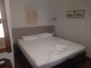 a bedroom with a white bed with two towels on it at Villa Venezia in Chania
