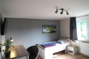 - une chambre avec un lit, une table et une fenêtre dans l'établissement Komfortable Ferienwohnung in der Lüneburger Heide, à Sprakensehl
