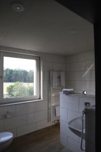 a bathroom with a tub and a sink and a window at Komfortable Ferienwohnung in der Lüneburger Heide in Sprakensehl