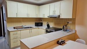 a kitchen with white cabinets and a counter top at Nice Studio Near The Sea in Ras al Khaimah