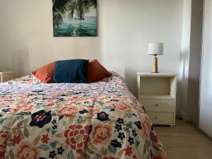1 dormitorio con 1 cama con un edredón colorido en Moderno y hermoso semi piso en Playa Grande en Mar del Plata