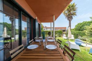 um deque com mesas e cadeiras numa casa em Espectacular Casa Playa Saians em Vigo
