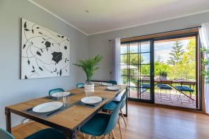 uma sala de jantar com uma mesa de madeira e cadeiras azuis em Espectacular Casa Playa Saians em Vigo