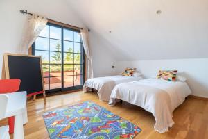 dwa łóżka w pokoju z dużym oknem w obiekcie Espectacular Casa Playa Saians w mieście Vigo