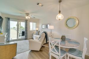a dining room and living room with a table and chairs at Gulf Shores Condo with Private Balcony on the Beach! in Gulf Highlands