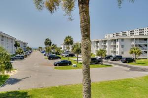 un estacionamiento en un complejo de apartamentos con coches aparcados en Gulf Shores Condo with Private Balcony on the Beach!, en Gulf Highlands