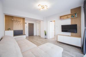 ein Wohnzimmer mit Sofa und Flachbildfernseher in der Unterkunft Creamy Wood Haven in Oradea