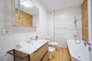 ein Badezimmer mit Waschbecken, Toilette und Badewanne in der Unterkunft Creamy Wood Haven in Oradea + 25 Fotos