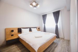 ein Schlafzimmer mit einem großen Bett und einem Fenster in der Unterkunft Creamy Wood Haven in Oradea
