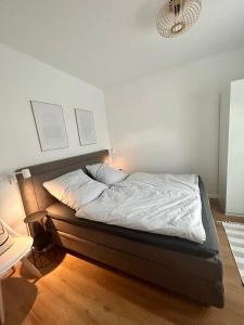 a bedroom with a bed with white sheets at Noorden Stuuv in Wittenborn