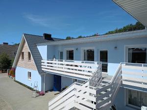 una casa bianca con ringhiera bianca e scale di Rybacki Domek 50 metrów do morza! a Dziwnów