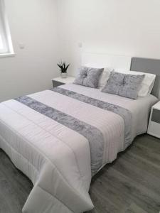ein großes weißes Bett in einem weißen Schlafzimmer in der Unterkunft Alojamento familia Carvalhais in Ponte de Vagos