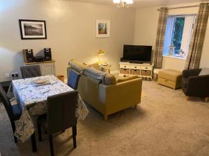 a living room with a couch and a table and a television at Idillic Two bed country cottage in Kirkby Thore