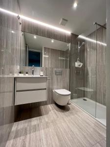 a bathroom with a toilet and a sink and a shower at Mar-à-Vista Apartment Nazaré in Nazaré