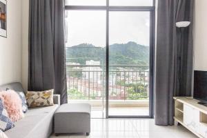 a living room with a couch and a large window at Very fancy strategic suites in Bayan Lepas
