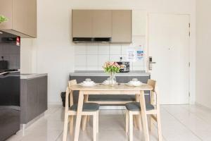 a kitchen with a table and chairs with flowers on it at Very fancy strategic suites in Bayan Lepas