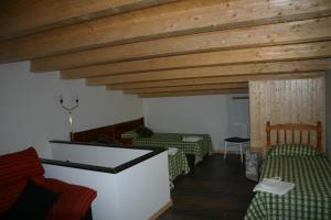 una sala de estar con 2 camas y techos de madera. en Amistad y convivencia 2, en Barahona