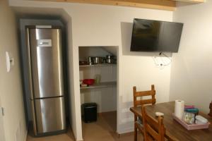 a kitchen with a stainless steel refrigerator and a table at Amistad y convivencia 2 in Barahona
