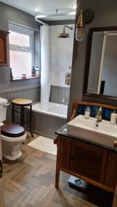 a bathroom with a sink and a toilet and a tub at Blue Ensign Cottage in Weymouth