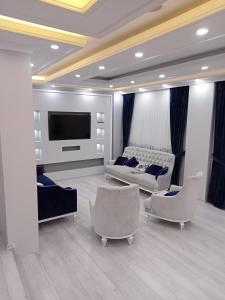 Il comprend un salon doté d'un mobilier blanc et d'une télévision à écran plat. dans l'établissement Kulaksız Köşk Villa, à Rize
