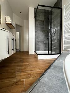 een badkamer met een douche en een houten vloer bij Ferienwohnung zum Scheibe-See in Hoyerswerda