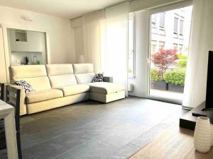 a living room with a couch and a large window at Urban Flat in Lugano