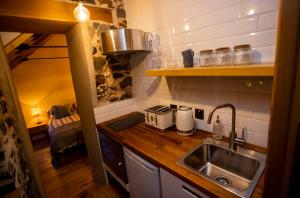 a small kitchen with a sink and a stove at The Woods at Whitepark Bay in Ballintoy