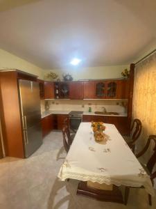 a kitchen with a table and a refrigerator at Mulla Apartment in Sarandë