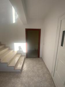 a hallway with stairs and a door in a building at Mulla Apartment in Sarandë +1 photo