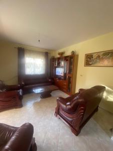 a living room with leather furniture and a television at Mulla Apartment in Sarandë