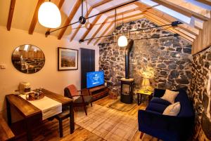 a living room with a stone wall at The Woods at Whitepark Bay in Ballintoy