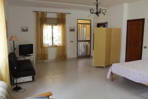 ein Schlafzimmer mit einem Bett, einem Stuhl und einem TV in der Unterkunft Villa Giù, indipendent villa near airport and sea in Cinisi