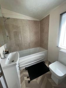 y baño con bañera, lavabo y aseo. en Sea view deluxe lodge en Lowestoft