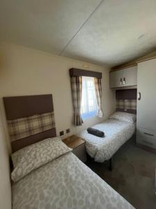 een slaapkamer met 2 bedden en een raam bij Sea view deluxe lodge in Lowestoft