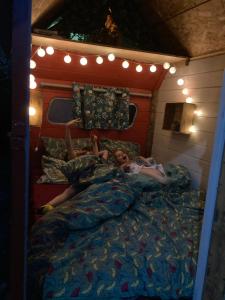 Una joven acostada en la cama en un marco de cama en Authentique roulotte foraine en Arlés