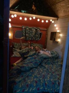 a young girl laying in bed in a bed frame at Authentique roulotte en Camargue in Arles