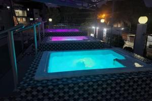 una piscina cubierta por la noche con luces moradas en Cozy apartment in Samana with Jacuzzi, en Santa Bárbara de Samaná