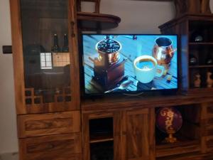 a tv in a wooden cabinet with a cup of coffee at My house 3 in Nador