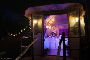 a room with a kitchen with purple lighting and a door at Authentique roulotte en Camargue in Arles +13 photos