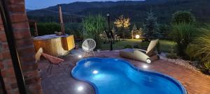 a backyard with a swimming pool and a hot tub at Chata w Grapie in Koniaków