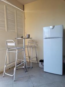 亞維儂的住宿－Appartement Jean Vilar，厨房配有桌子、两把椅子和冰箱