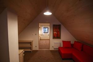 a living room with a red couch in a attic at Domek w górach SmoLenisko in Nowy Targ