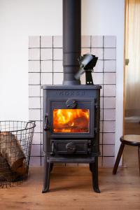 a black stove in a living room with a fire at Knus boshuisje onder de eiken in Ermelo