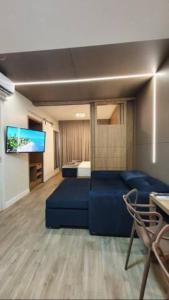 sala de estar con sofá azul y TV en Costa Sul Beach Hotel en Balneario Camboriú