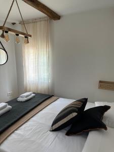 - une chambre avec un grand lit et des oreillers noirs et blancs dans l'établissement Casa Amodiño, à Belesar