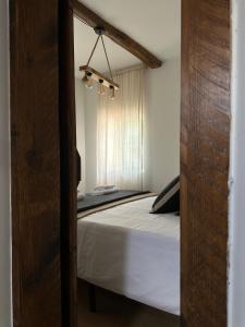 een slaapkamer met een bed met witte lakens en een raam bij Casa Amodiño in Belesar
