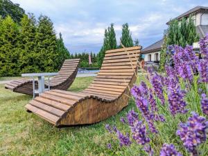 2 sillas y una mesa en un jardín con flores púrpuras en Ranczo Sielanka, en Jamielnik